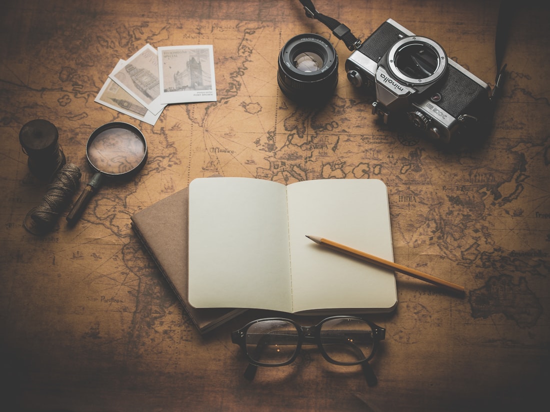 A travel map, notebook and camera laid out for trip planning
